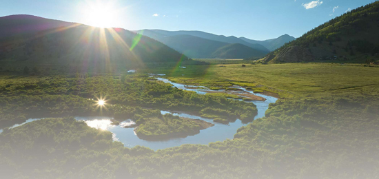 A river winding through the land with mountains in the background